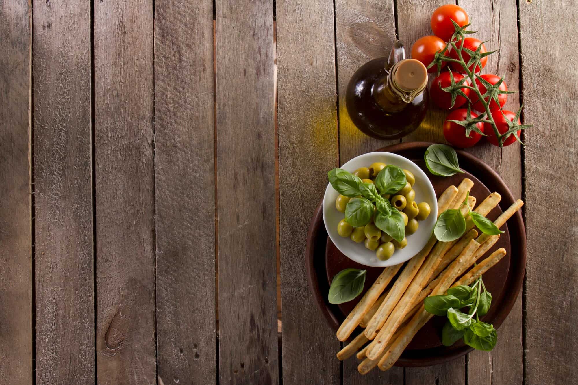 Olives, breadsticks, tomatoes, and oil